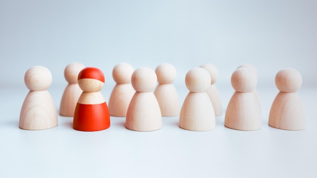 A red wooden figure standing with a team to influence