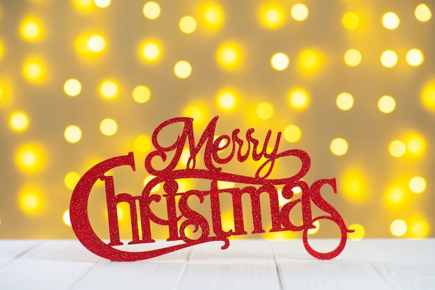 Photo red wooden glitter lettering merry christmas on yellow blurred light bokeh background