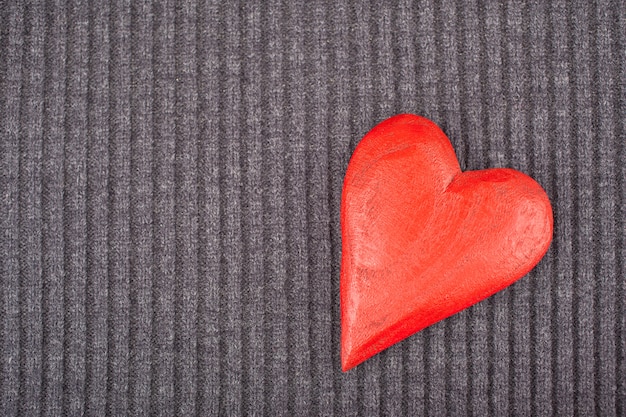 Photo red wooden heart on knitted