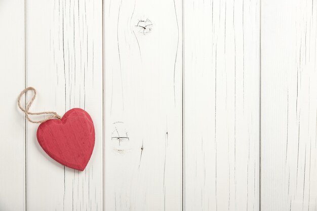 Cuore di legno rosso su fondo di legno bianco