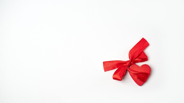 밝은 (흰색) 배경에 붉은 나비 매듭으로 붉은 나무 마음. 발렌타인 데이 컨셉