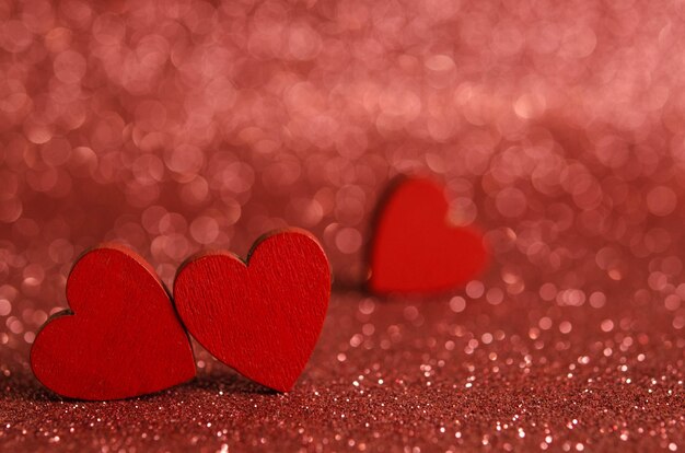 Red wooden hearts on a shiny surface