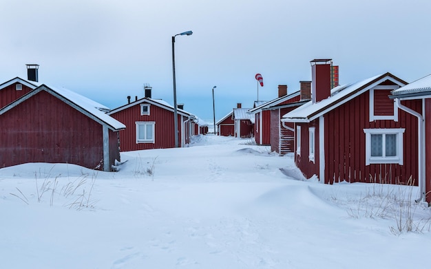 Red wooden house in the snow on the seashore