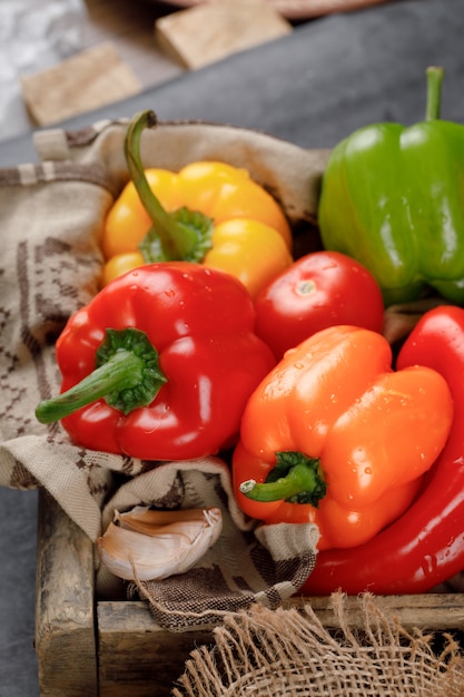 Red and yellow bell peppers on rustic tray.