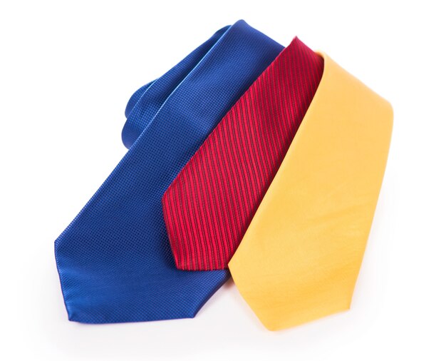 Красные желтые и синие галстуки. шелковый деловой галстук свернутый на белом фоне