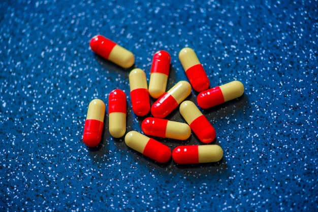 Photo red and yellow capsule medication on a blue background