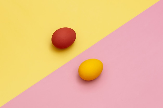 Red and yellow Easter eggs on yellow and pink backgrounds