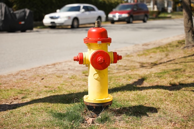 A red and yellow fire hydrant is on the side of the road.