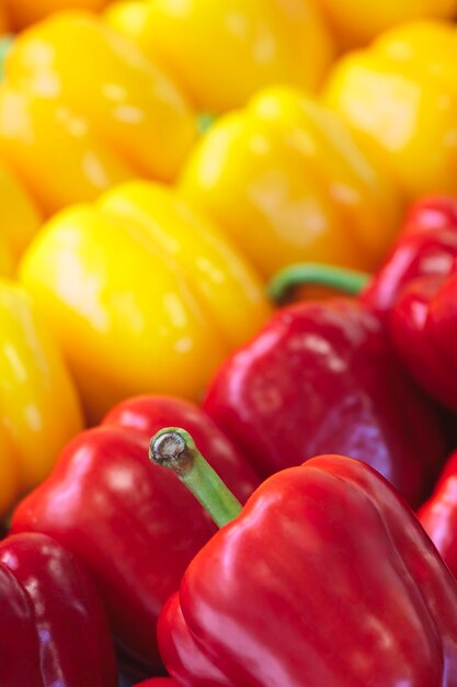 Red and yellow fresh peppers on display in a market