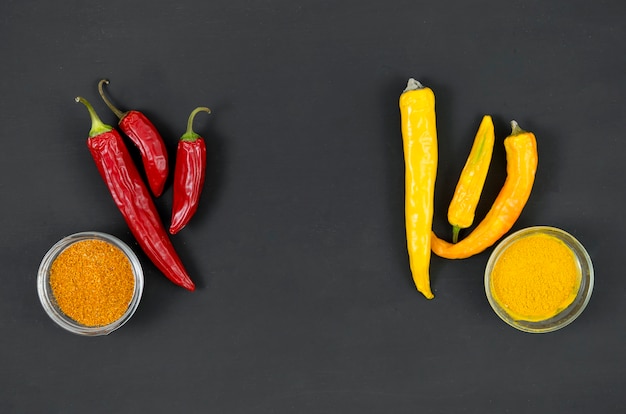 Red and yellow peppers on a grey background top view