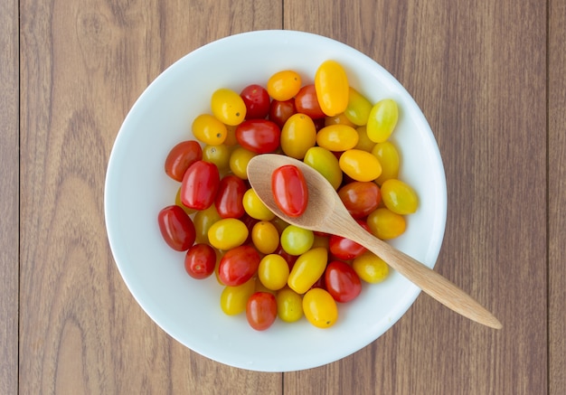 Red and yellow tomatoes with a spoon