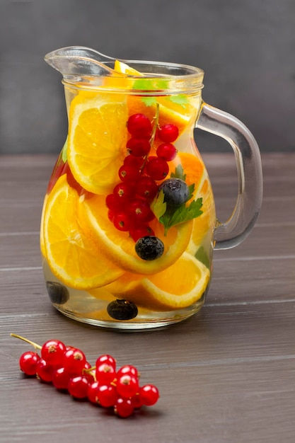 Redcurrant and orange infused water in glass jug