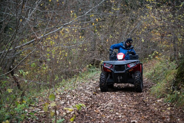 Redder doet uitkijk in het bos op een quad