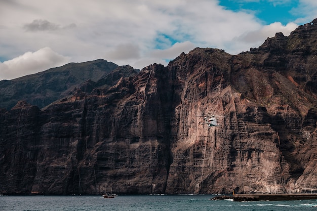 Reddingshelikopter die tussen de kliffen van Los Gigantes vliegt