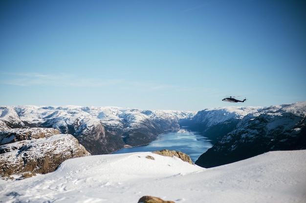 Reddingshelikopter vliegt over de Preikestolen en Lysefjors in Noorwegen