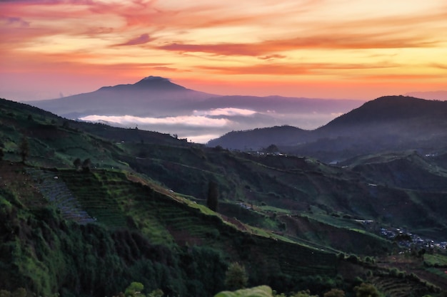 Photo reddish evening sky over sindoro mountain in wonosobo indonesia