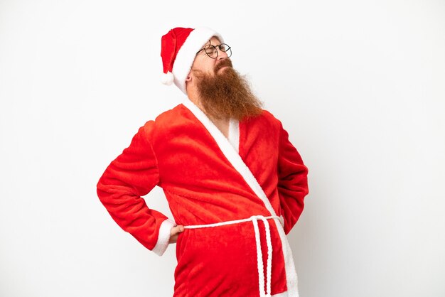 Photo reddish man disguised as santa claus isolated on white suffering from backache for having made an effort