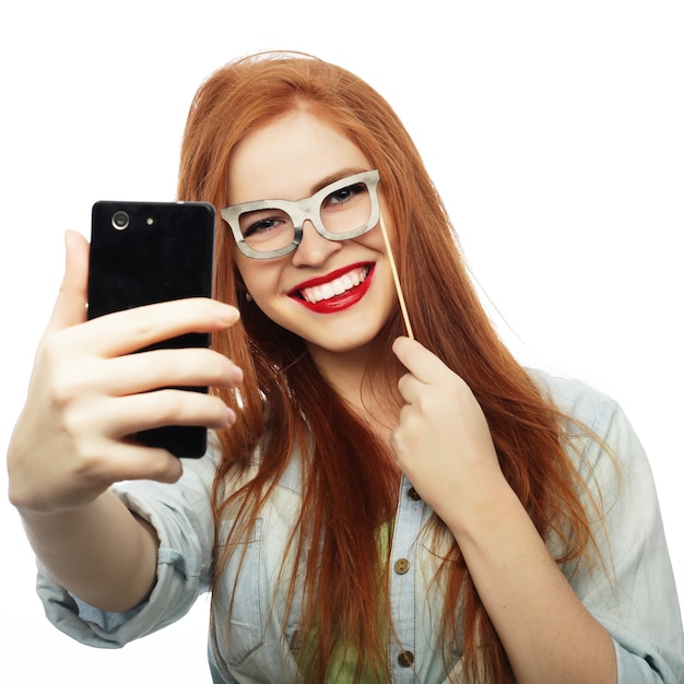 Ragazza dai capelli rossi pronta per la festa, scatta un selfie