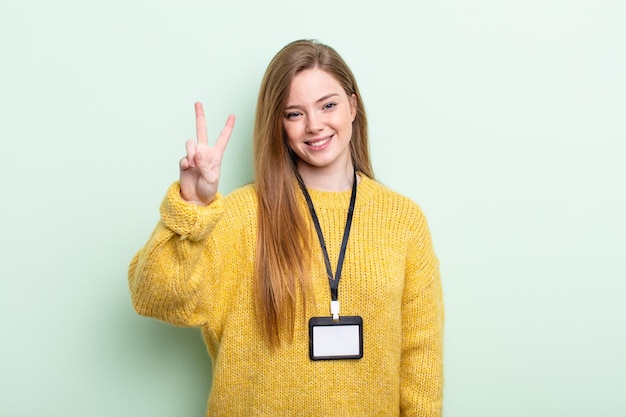 Redhair sorridente e dall'aspetto amichevole che mostra il concetto di carta di accreditamento numero due