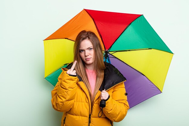 Redhair woman feeling angry annoyed rebellious and aggressive umbrella concept