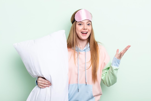 Photo redhair woman feeling happy surprised realizing a solution or idea pajamas and pillow concept