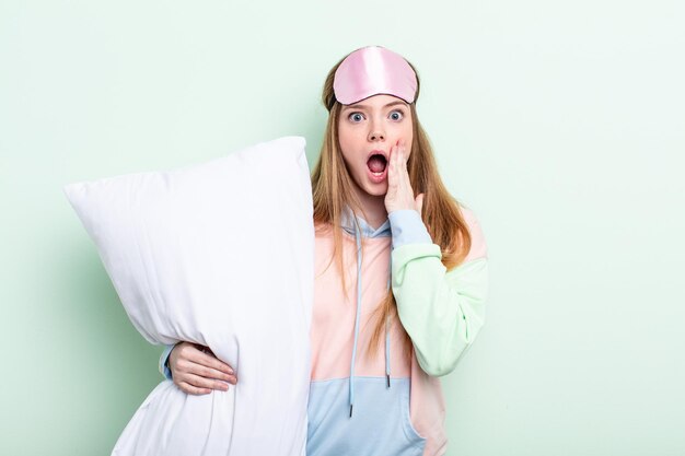 Redhair woman feeling shocked and scared pajamas and pillow concept