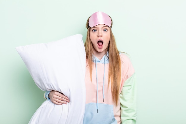 Redhair woman looking very shocked or surprised pajamas and pillow concept