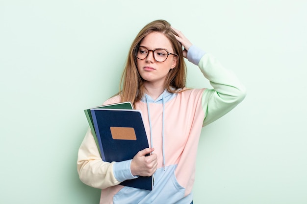 幸せに笑って、空想にふけったり、疑ったりする赤毛の女性。学生の概念