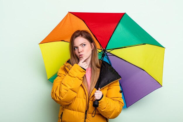 redhair woman thinking, feeling doubtful and confused. umbrella concept