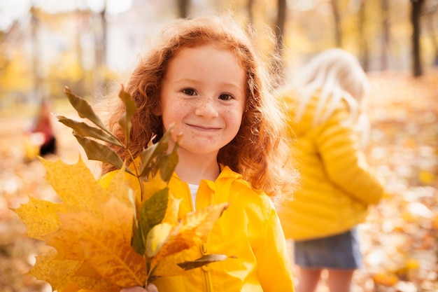 Redhaired girl in autumn leaves