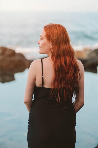 Redhaired girl in front of the sea