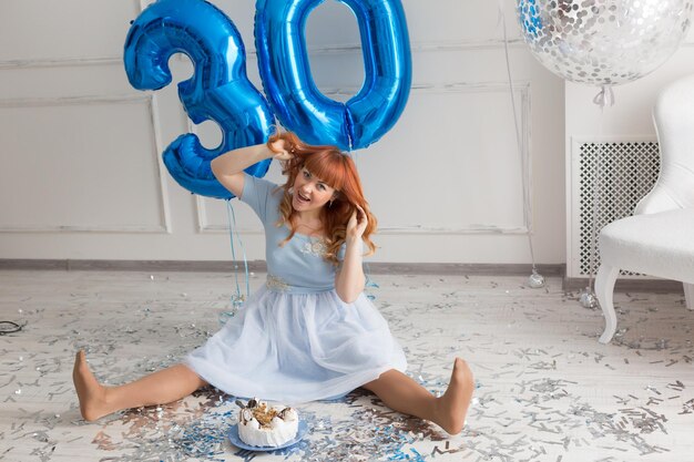 A redhaired girl with a large bouquet of flowers the girl in the blue dress