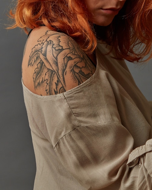 Redhaired girl with a shoulder tattoo