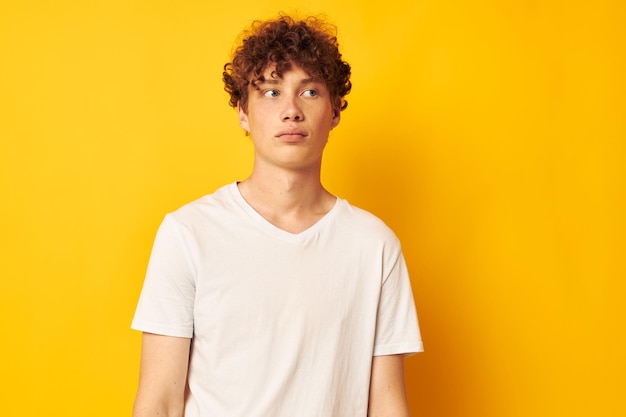 Redhaired guy in a white tshirt on a yellow background