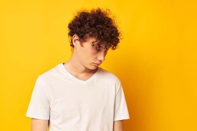 Redhaired guy in a white tshirt on a yellow background