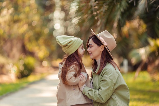 Redhaired mother and daughter are walking in the park family leisure in the city