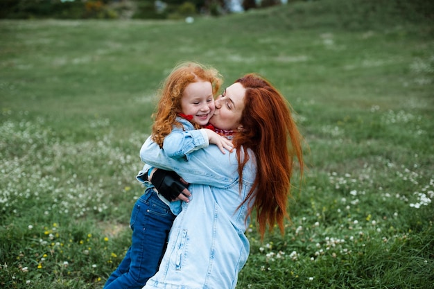 Redhaired 엄마와 딸은 자연에서 즐거운 시간을 보냅니다.