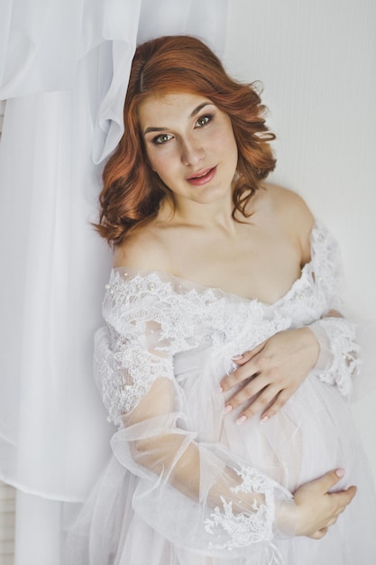 Redhaired pregnant girl in a white robe 6850