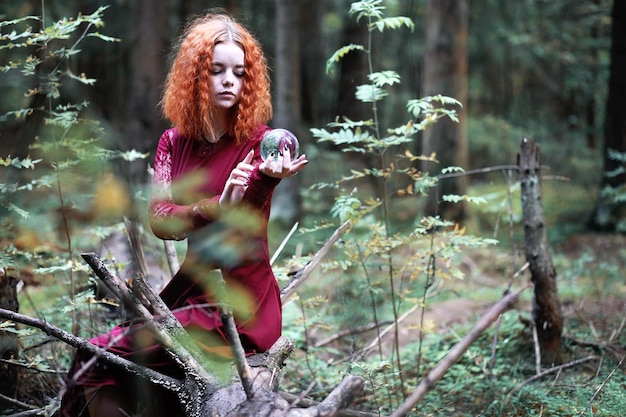 redhaired 마녀는 수정 구슬로 의식을 개최합니다.