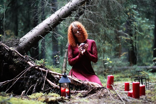 The redhaired witch holds a ritual with a crystal ball