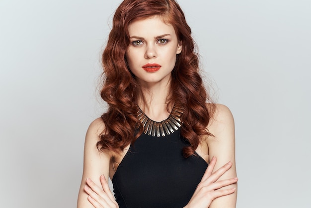 Redhaired woman in black dress red lips glamor posing