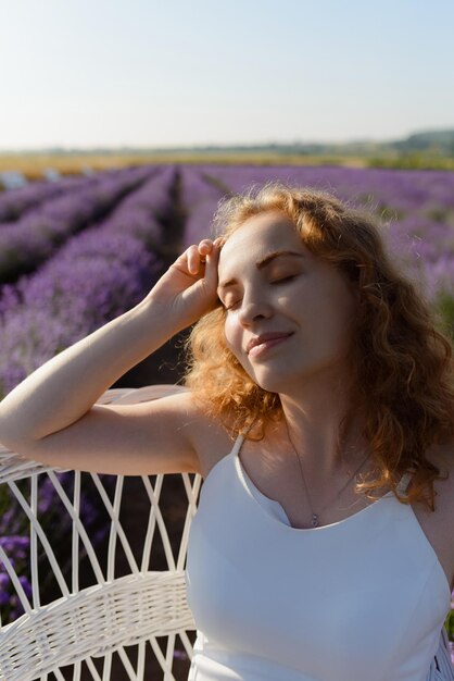 A redhaired woman touches the lock of hair in a field of lavender