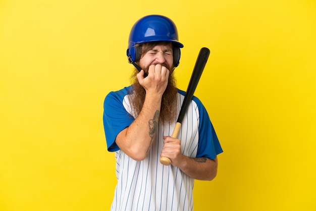 Redhead baseball player man with helmet and bat isolated on yellow background having doubts