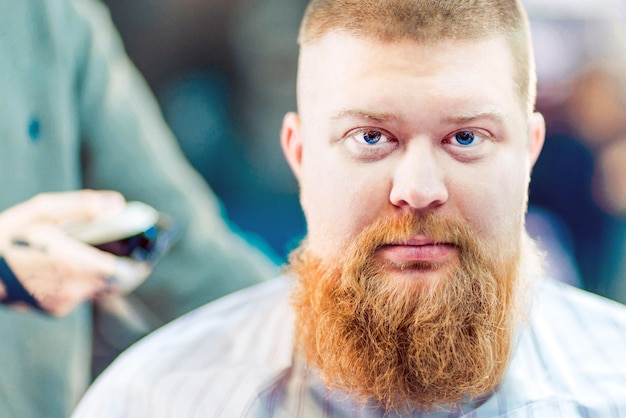 A redhead bearded man in barbershop