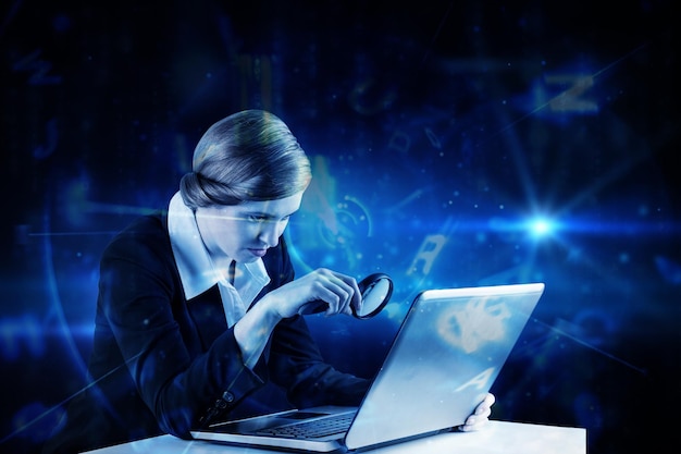 redhead businesswoman using her laptop against blue background with letters