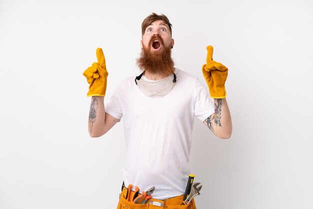 Redhead electrician man with long beard over white wall pointing with the index finger a great idea