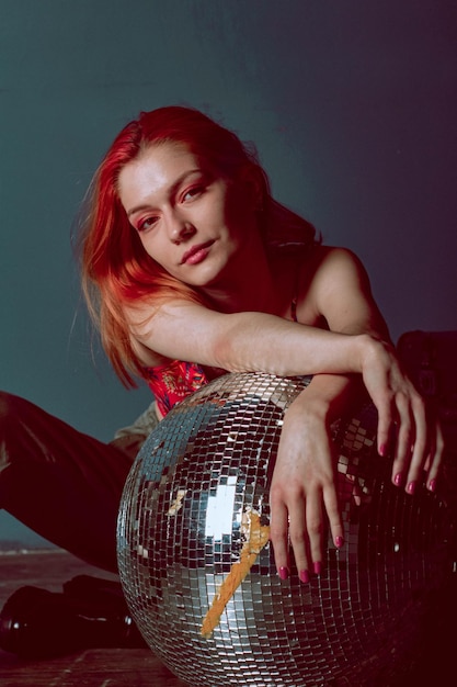 Redhead girl in a red top with a disco ball