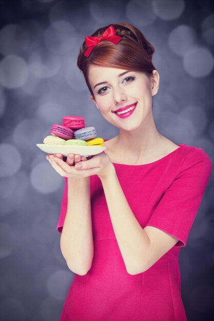 Redhead girl with macaron for St. Valentine Day.