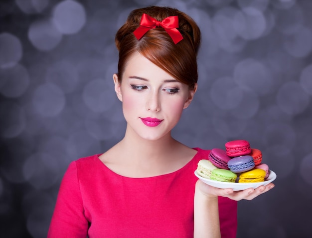 Redhead girl with macaron for St. Valentine Day.