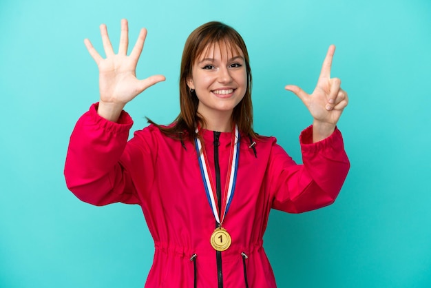 Рыжая девушка с медалями на синем фоне, считая семь пальцами